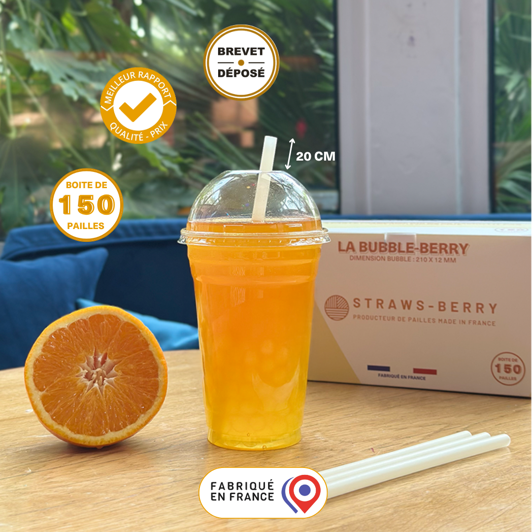 Paille Bubble-Berry en fibres végétales françaises de 20 cm dans un gobelet en plastique transparent à emporter avec un jus d'orange. Fabriquée en France, brevet déposé et boîte de 150 pailles