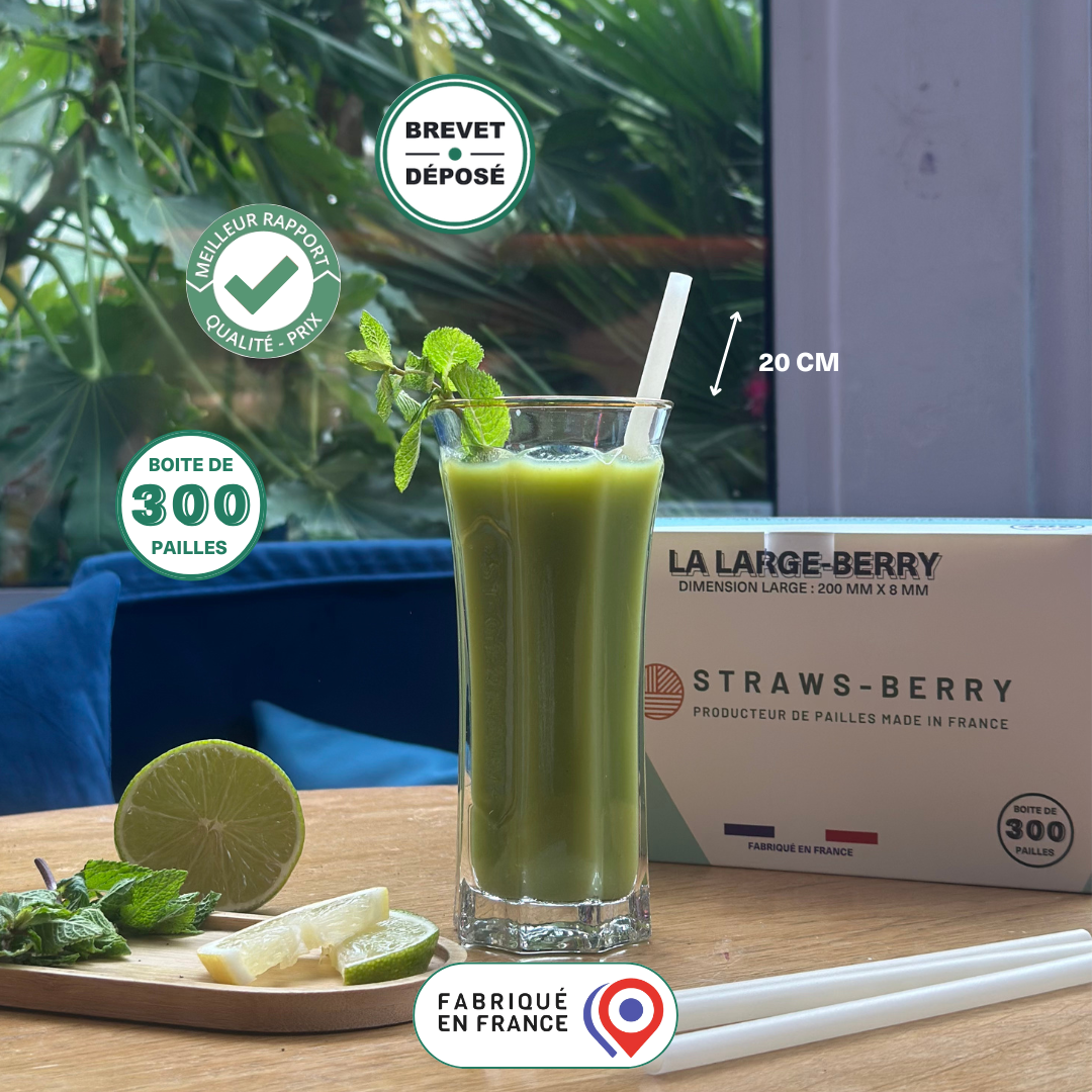 smoothie vert detox posé sur une table en bois dans un verre avec une paille réutilisable large berry